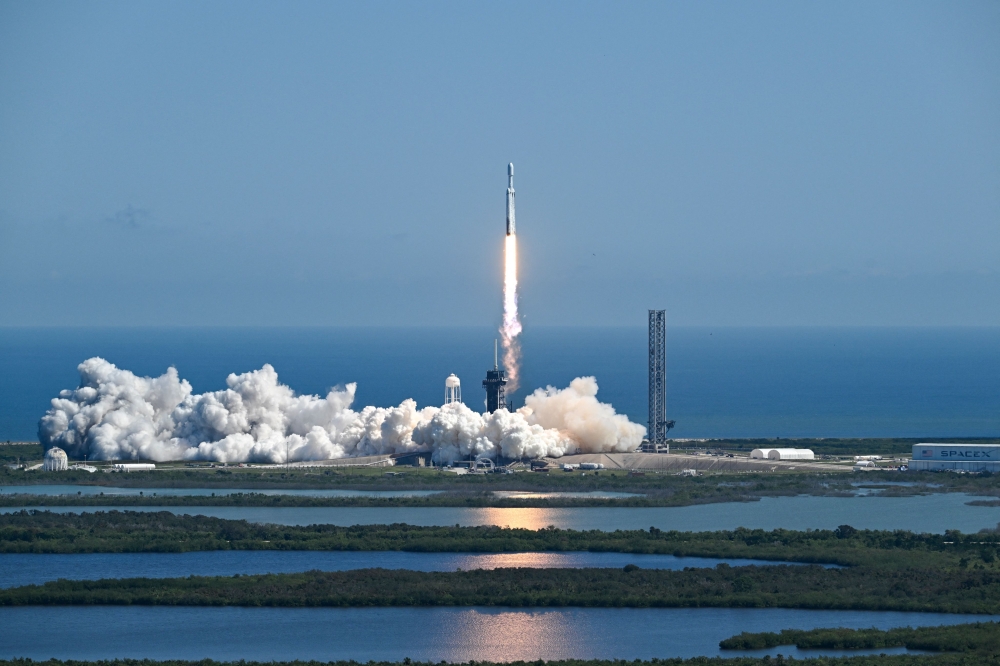 A SpaceX Falcon Heavy rocket with the Europa Clipper spacecraft aboard launches from Launch Complex 39A at NASA's Kennedy Space Center in Cape Canaveral on October 14, 2024. Photo by CHANDAN KHANNA / AFP