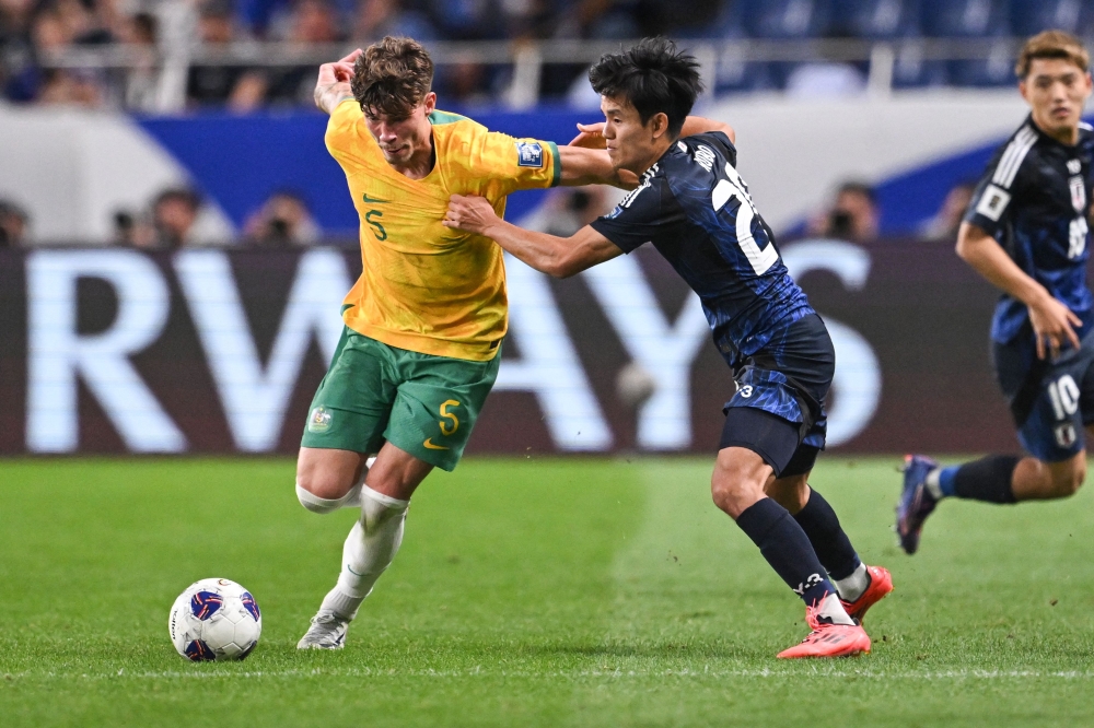Australia's Jordan Bos (L) and Japan's Takefusa Kubo compete for the ball during the FIFA World Cup 2026 Asian zone qualifiers football between Japan and Australia at Saitama Stadium in Saitama on October 15, 2024. (Photo by Philip FONG / AFP)