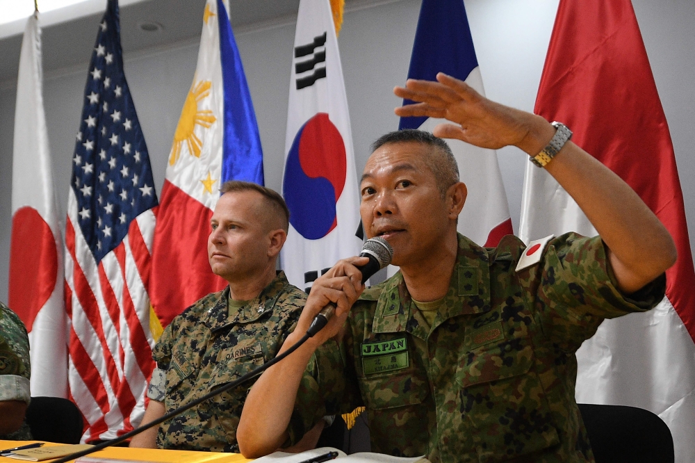 Japan's Ground Self-Defense Force Major-General Hajime Kitajima (R) speaks as US Marines exercise representative Colonel Stuart Glenn looks on during a press conference following the opening ceremony of the Kamandag 2024 joint military exercise at the Philippine Marines officers club at Fort Bonifacio in Manila on October 15, 2024. (Photo by Ted Aljibe / AFP)
