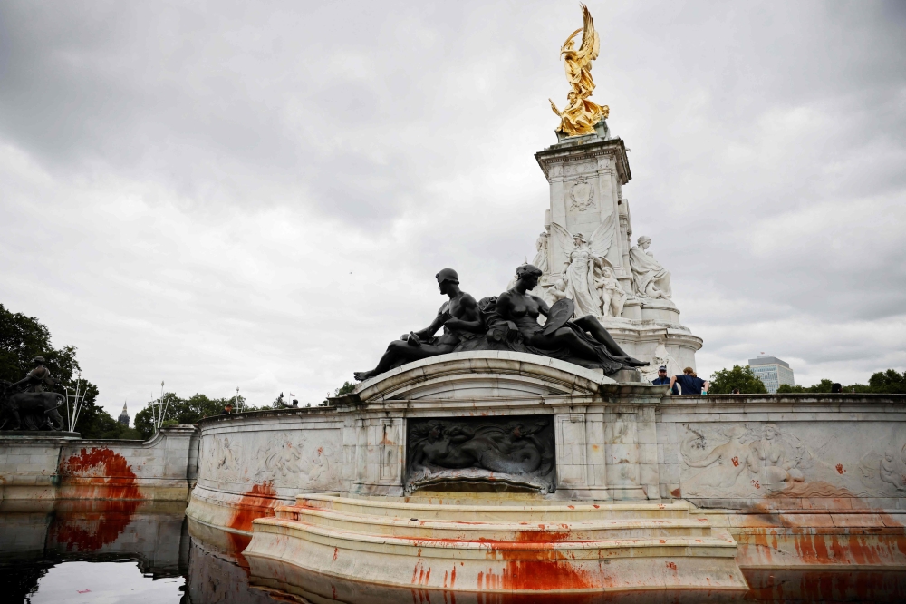 Red stains are seen on the Queen Victorial Memorial outside Buckingham Palace in central London on August 26, 2021 after climate activists from the Animal Rebellion conducted a protest action. (Photo by Tolga Akmen / AFP)