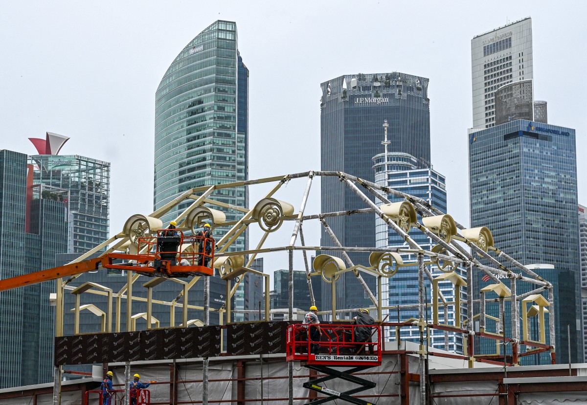 File photo of workers assembling a structure near the financial business district in Singapore.