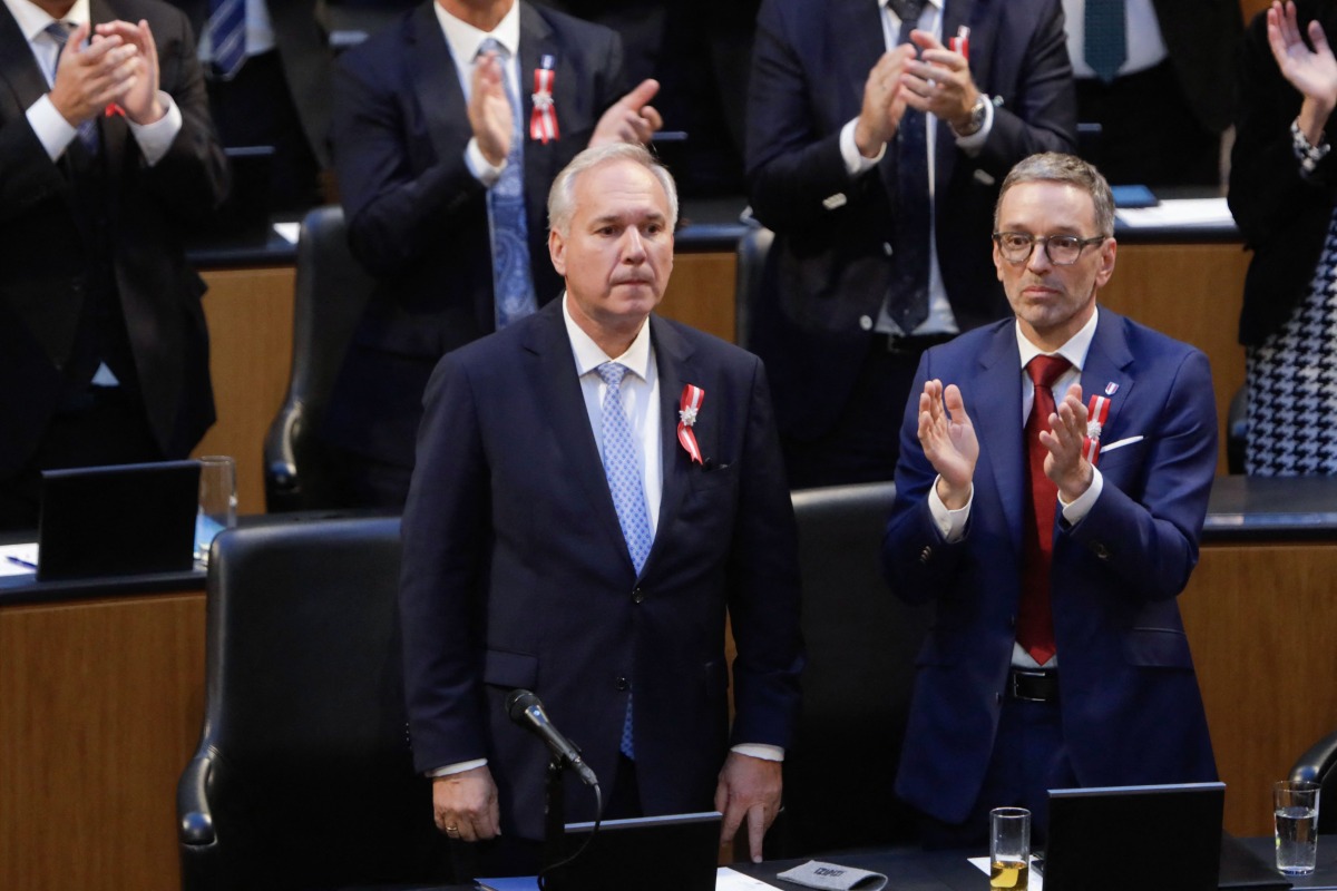 The Chairman of Austria's Freedom Party (FPOe) Herbert Kickl (R) and other MPs applaud after the election of Walter Rosenkranz (L), MP of Austria's Freedom Party (FPOe), as new parliament president in the plenary of the Austrian Parliament in Vienna on October 24, 2024, as the parliament meets for the first time after the National Council elections. (Photo by Alex HALADA / AFP)

