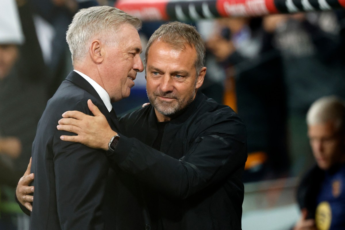 Real Madrid's Italian coach Carlo Ancelotti (L) and Barcelona's German coach Hans-Dieter Flick hug each other before the Spanish league football match between Real Madrid CF and FC Barcelona at the Santiago Bernabeu stadium in Madrid on October 26, 2024. (Photo by OSCAR DEL POZO / AFP)
