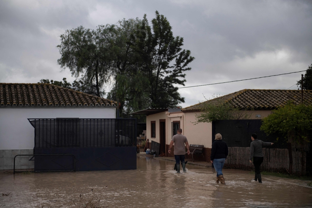 People walk in a flooded street in Jerez de la Frontera, near Cadiz, on October 31, 2024, after heavy rains hit southern Spain. (Photo by Jorge Guerrero / AFP)