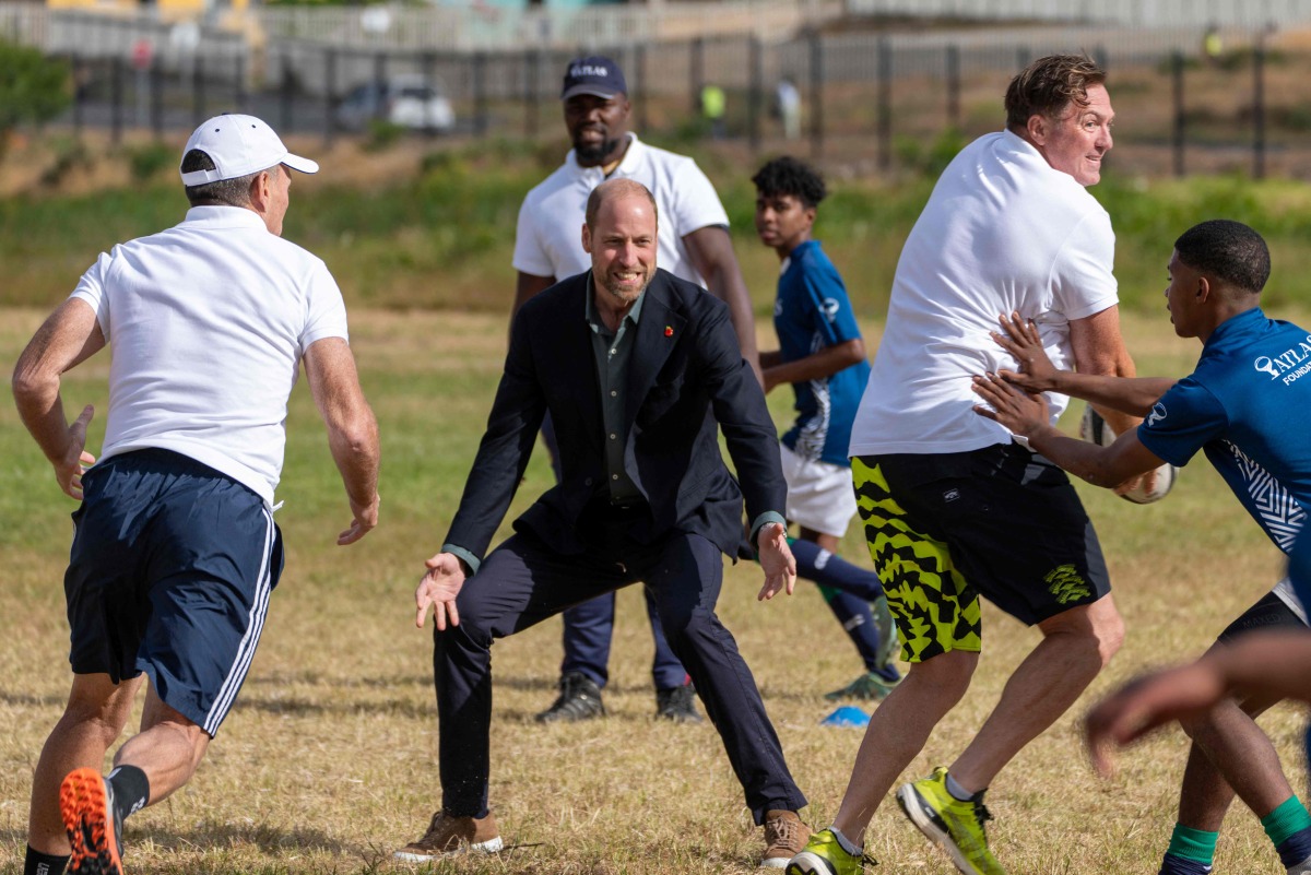 Britain's Prince William (C), Prince of Wales, plays rugby with students during his visit at the Ocean View Secondary School in Cape Town on November 4, 2024. (Photo by Jerome Delay / POOL / AFP)

