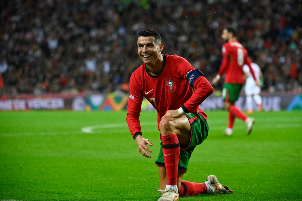 Portugal's forward Cristiano Ronaldo (L) reacts during the UEFA Nations League, League A, Group 1 football match between Portugal and Poland at the Dragao stadium in Porto, on November 15, 2024. (Photo by Miguel Riopa / AFP)