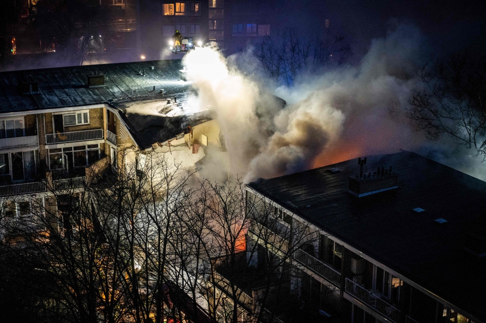 Firemen try to douse a fire following a fire and an explosion at a residential building in The Hague on December 7, 2024. (Photo by Josh Walet / ANP / AFP) 