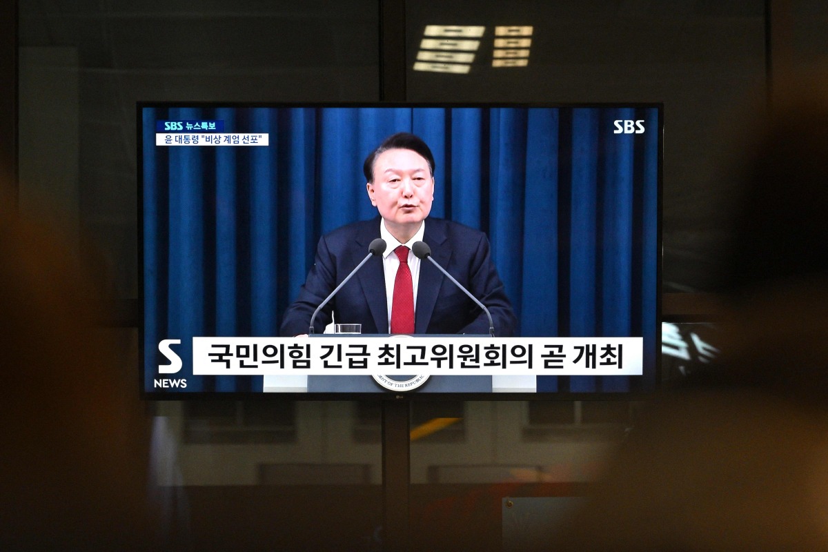 (Files) South Korea's President Yoon Suk Yeol is seen speaking on a television in a train station in Seoul late on December 3, 2024, Photo by Anthony WALLACE / AFP

