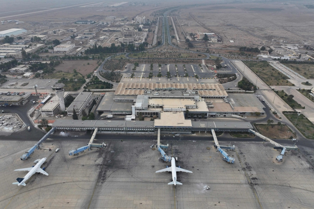 An aerial view shows passenger planes of Syria's private airline company Cham Wings on the tarmac of the closed international airport of Damascus on December 11, 2024.  (Photo by Omar Haj Kadour / AFP)