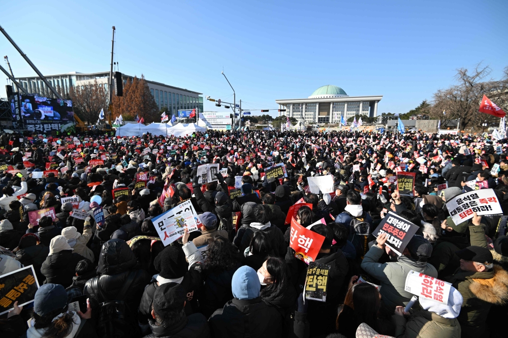 People take part in a protest calling for the ouster of South Korea's President Yoon Suk Yeol outside the National Assembly in Seoul on December 14, 2024. (Photo by Jung Yeon-je / AFP)
 