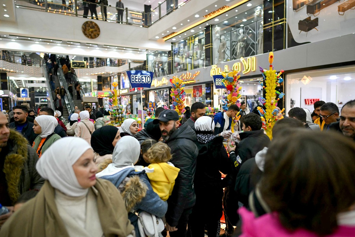 People shop at a shopping mall in the town of al-Dana, near Sarmada, in the northern Syrian province of Idlib on December 13, 2024. The crowd wanders in awe through the aisles saturated with lights, dazzled by the abundance of goods displayed before them in the heart of the former rebel stronghold in northwestern Syria. Photo by OZAN KOSE / AFP.
