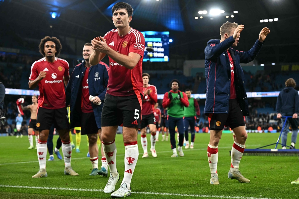 Manchester United's English defender #05 Harry Maguire applauds the fans following the English Premier League football match, on December 15, 2024. (Photo by Paul Ellis / AFP) 