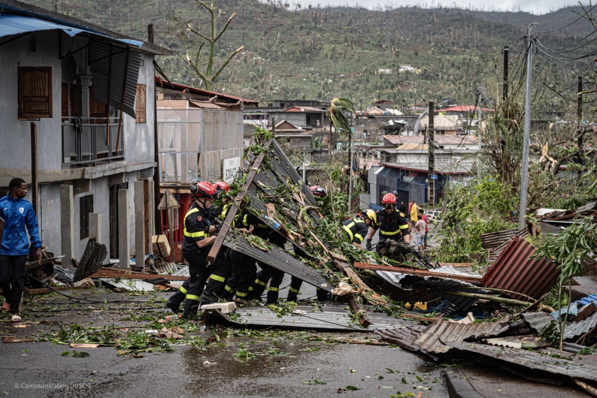 This handout aerial photograph taken and released by the French Securite Civile on December 15, 2024 shows French Security Civile members removing debris in Combani, on the French Indian Ocean territory of Mayotte, after the cyclone Chido hit the archipelago. (Photo by Handout / Securite Civile / AFP)
