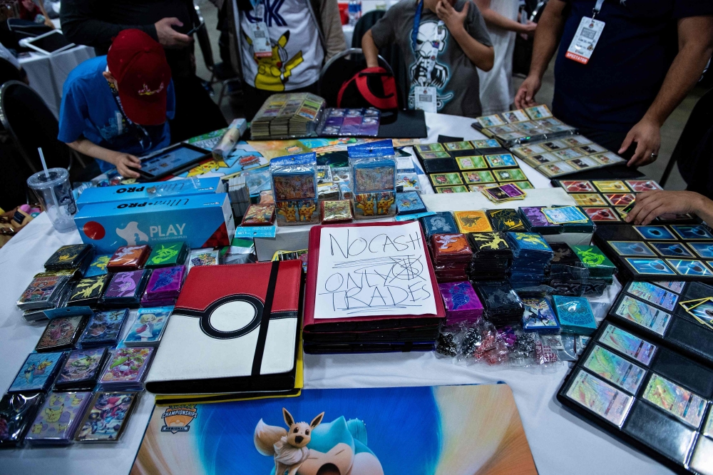 (Files) People trade Pokemon cards during the first day of the 2019 Pokemon World Championships at the Washington Convention Center August 16, 2019, in Washington, DC. (Photo by Brendan Smialowski / AFP)