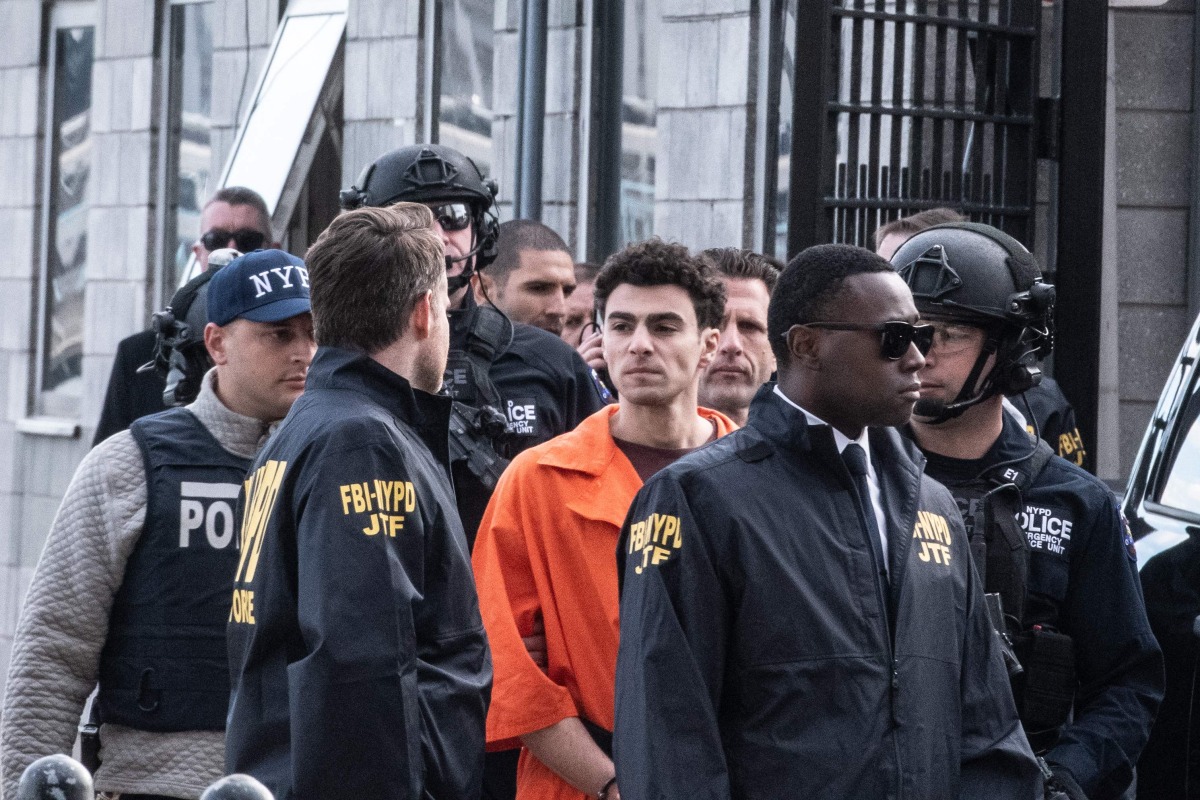 Luigi Mangione, suspect in the killing of UnitedHealthcare CEO Brian Thompson in New York City, arrives at a heliport with members of the NYPD on December 19, 2024 in New York City. Photo by STEPHANIE KEITH / GETTY IMAGES NORTH AMERICA / Getty Images via AFP