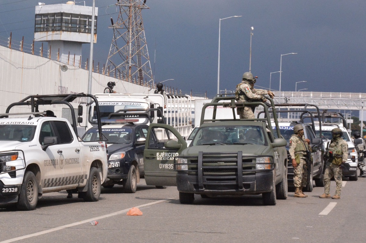 Mexican army soldiers and National Guard members stand guard outside the Tabasco State Social Rehabilitation Center (Creset) after a riot broke out inside the prison in Villahermosa, Tabasco State, Mexico, on December 19, 2024. (Photo by Maria CRUZ / AFP)
