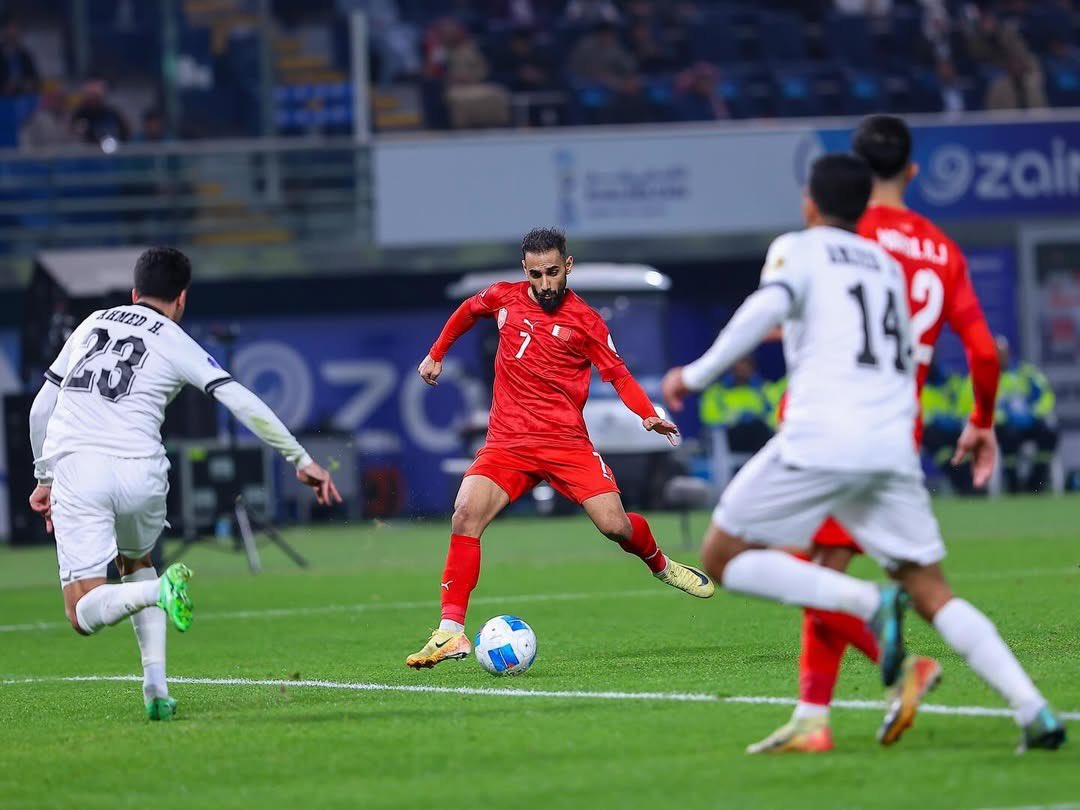 Bahrain's Ali Madan (centre) shoots to score a goal against Iraq.