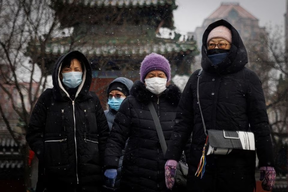 File: People wear face masks as they walk on a snowy morning as the coronavirus disease (COVID-19) continues in Beijing, China, on January 20, 2022. (Reuters)

