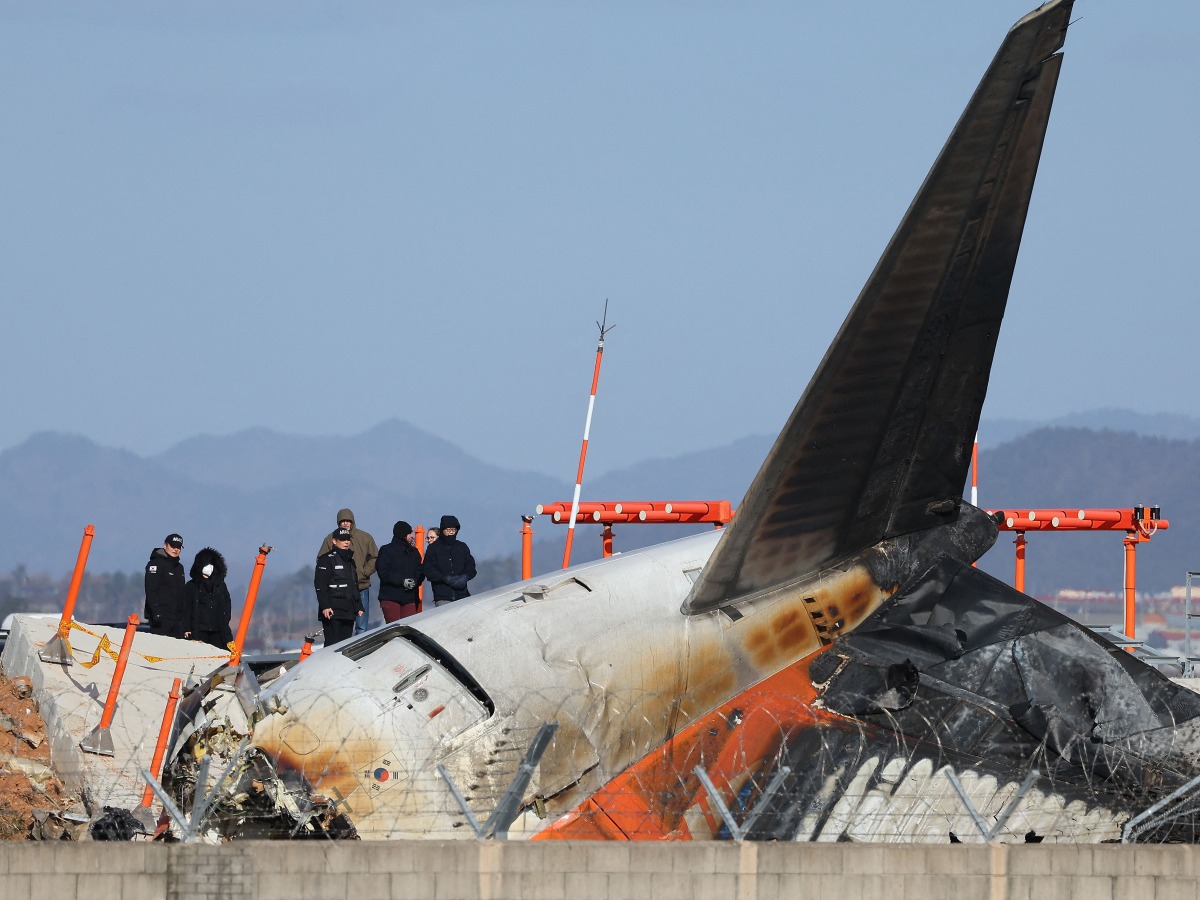 Investigators from South Korea and the US, including officials from the US National Transportation Safety Board (NTSB) and aircraft manufacturer Boeing, inspect the scene where a Jeju Air Boeing 737-800 aircraft crashed and burst into flames at Muan International Airport in Muan, some 288 kilometres southwest of Seoul on December 31, 2024. Photo by YONHAP / AFP
