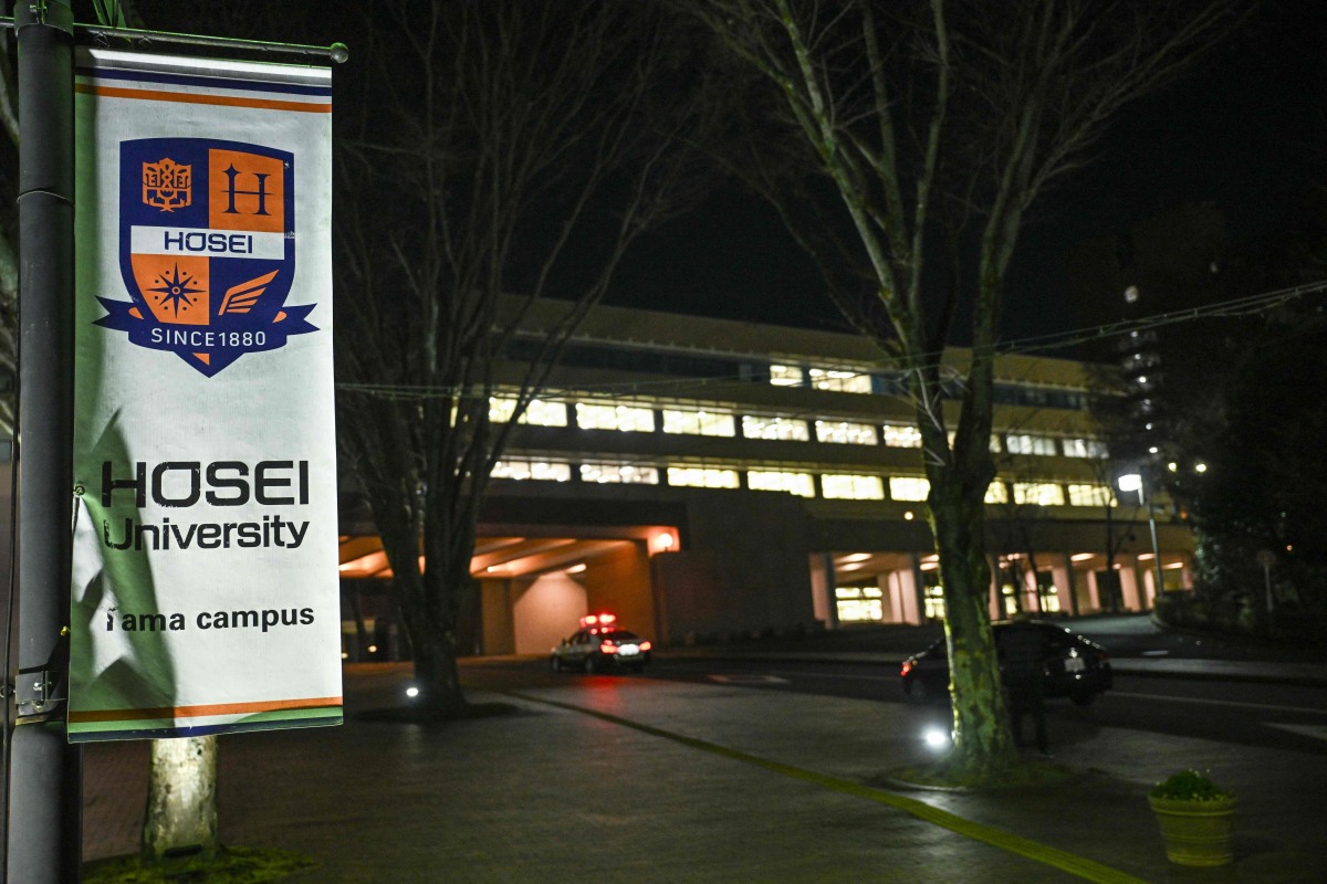 A banner (L) for Hosei University is pictured near the entrance to the university's Tama campus after a woman brandished a hammer inside a classroom, in Machida in the western suburbs of Tokyo on January 10, 2025. Photo by Philip FONG / AFP