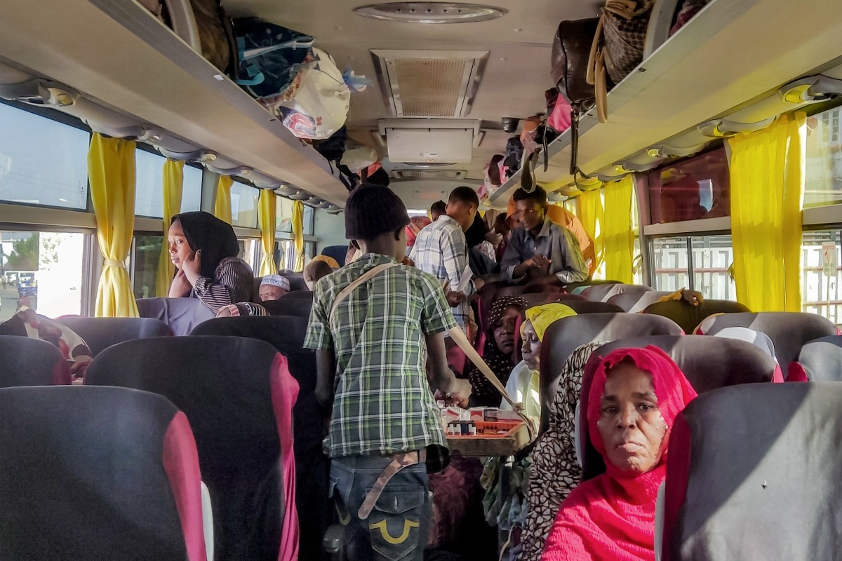 People displaced by conflict ride aboard a bus from Port Sudan in northeastern Sudan on January 7, 2025 to return home to the southern city of Singah in Sennar province, which was retaken by the Sudanese army forces from the Rapid Support Forces (RSF) in November 2024. (Photo by AFP)
