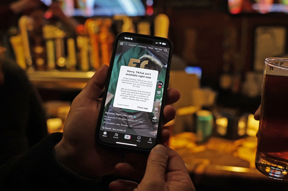 A TikTok user holds a phone showing the screen of the social media app on January 18, 2025 in Washington, DC. (Photo by Justin Sullivan/Getty Images/AFP)
