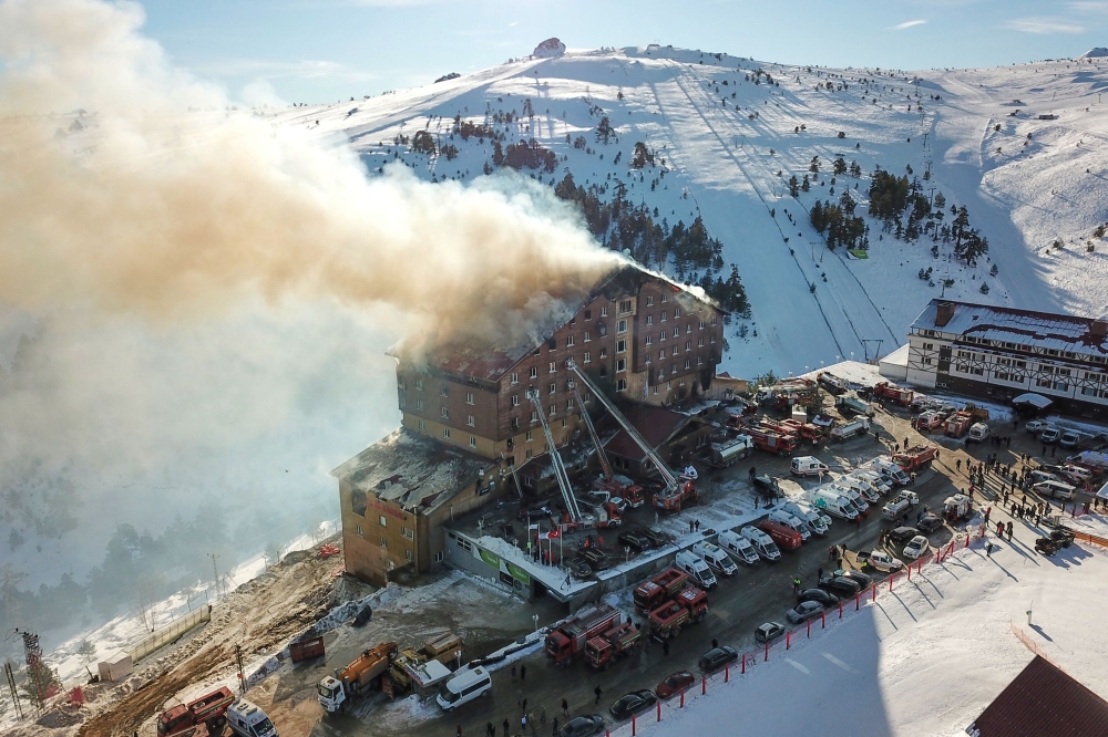 This handout photograph released by the Demiroren News Agency (DHA) on January 21, 2025, shows an aerial picture of a fire on the fourth floor of the 11-storey hotel in Bolu's Kartalkaya ski resort. (Photo by DHA (Demiroren News Agency) / AFP)

