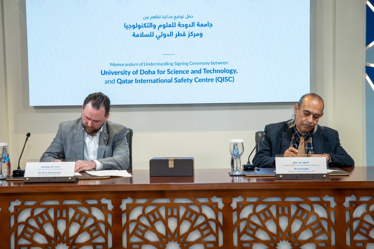 UDST and QISC officials signing the MoU.