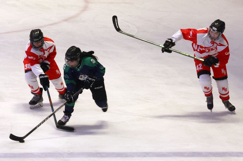 Players compete during the Iranian Women's League Ice Hockey match between team M.R and team Hockey Panda at the Iran Mall ice rink in Tehran on January 29, 2025. (Photo by Atta Kenare / AFP)