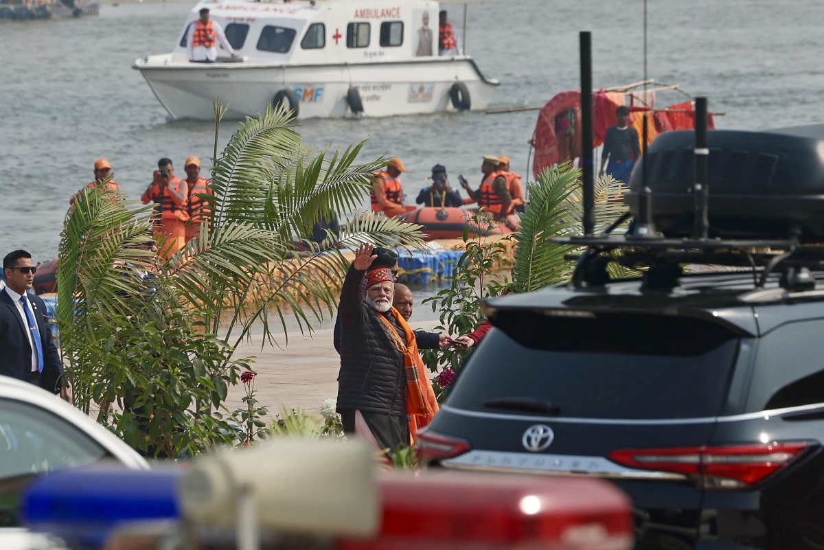 India's Prime Minister Narendra Modi (C) waves as he leaves after taking a holy dip in the sacred waters of Sangam, the confluence of Ganges, Yamuna and mythical Saraswati rivers during Maha Kumbh Mela festival, in Prayagraj on February 5, 2025. Photo by Niharika KULKARNI / AFP.
