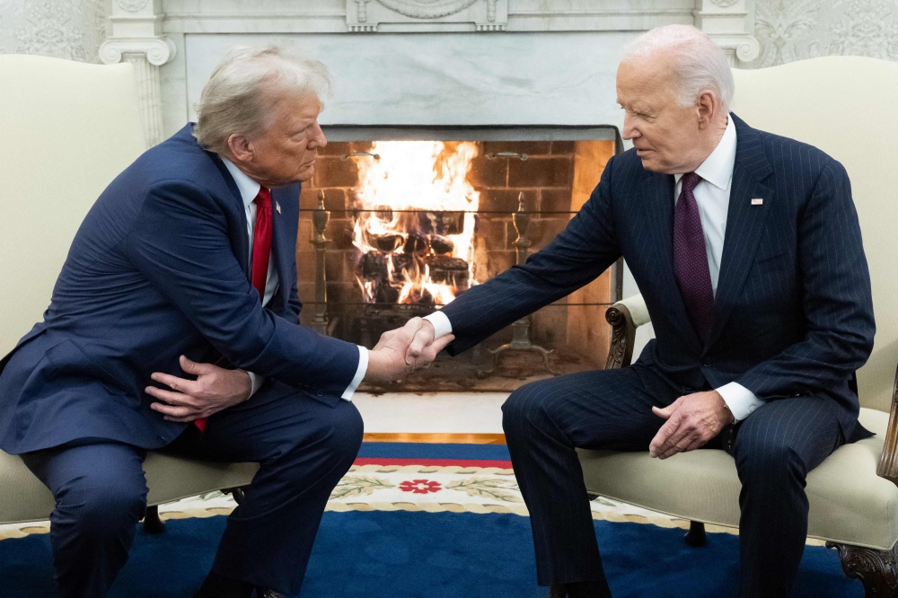 (Files) US President Joe Biden shakes hands with US President-elect Donald Trump during a meeting in the Oval Office of the White House in Washington, DC, on November 13, 2024. (Photo by SAUL LOEB / AFP)
 