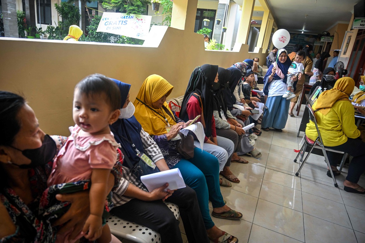 People wait at a community health centre during the opening day of the nationwide free health check-up (PKG) programme in Surabaya on February 10, 2025. (Photo by JUNI KRISWANTO / AFP)