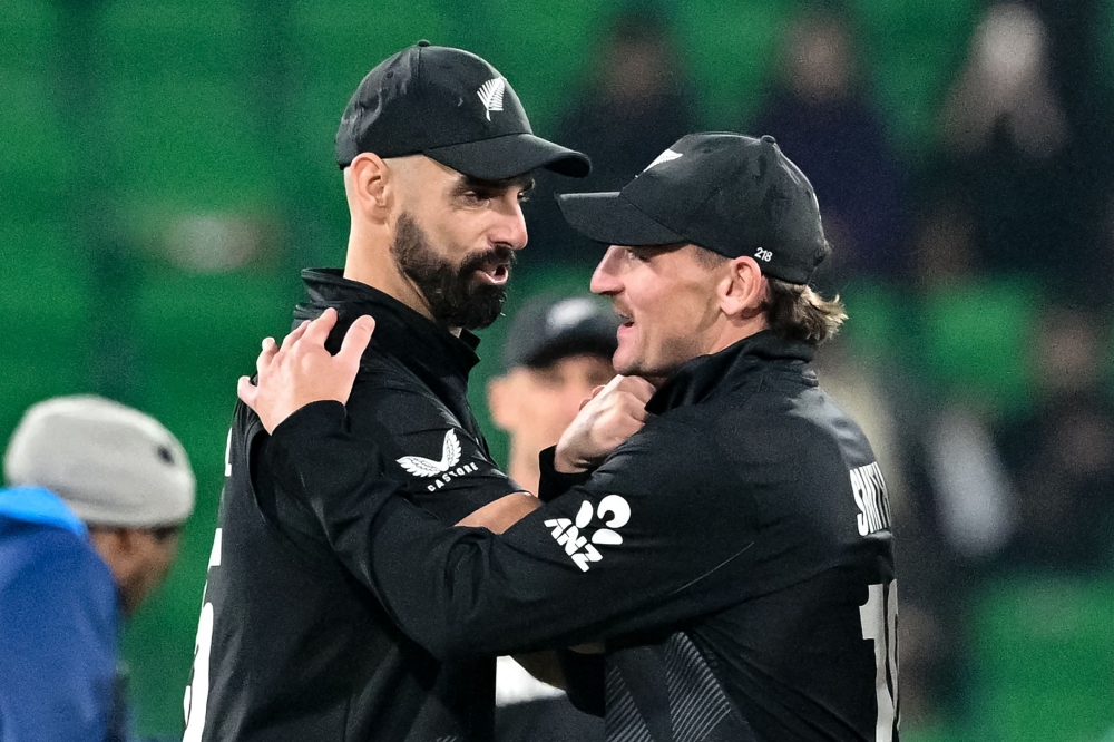New Zealand's Daryl Mitchell (L) and Nathan Smith celebrate their team's win at the end of the ICC Champions Trophy one-day international (ODI) semi-final cricket match between New Zealand and South Africa at the Gaddafi Stadium in Lahore on March 5, 2025. (Photo by Asif Hassan / AFP)
 