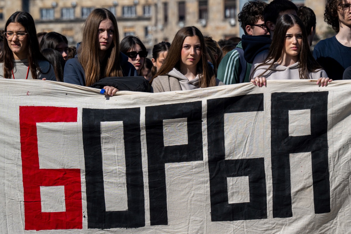 Demonstrators hold a banner reading 'Struggle' as students, pupils and citizens block a street in front of the National Assembly building in Belgrade, on March 4, 2025, standing in silence to pay tribute to the 15 victims of the tragedy at Novi Sad railway station in November 2024. Photo by Andrej ISAKOVIC / AFP