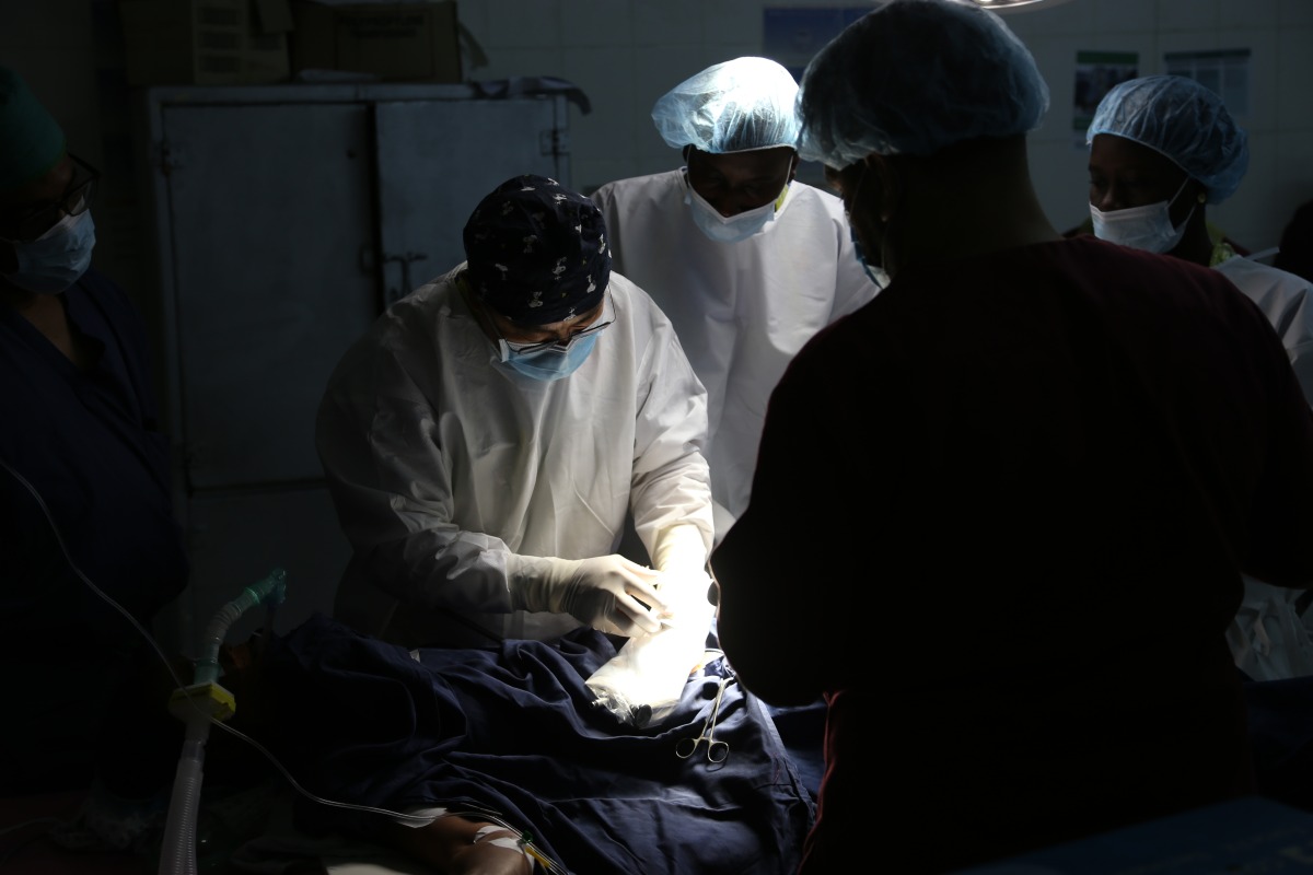 Cai Guiyang, the leader of the 22nd batch of the Chinese medical team, prepares to perform a surgery on a patient at an operating room of Edward Francis Small Teaching Hospital in Banjul, capital of Gambia, on March 12, 2025. (Xinhua/Si Yuan)
