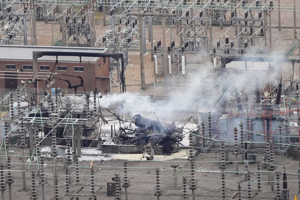 An aerial photograph taken on March 21, 2025 shows smoke billowing from a substation supplying power to Heathrow Airport amid efforts to douse the remainder of the flames after a fire broke out in Hayes, west London. (Photo by AFP)  