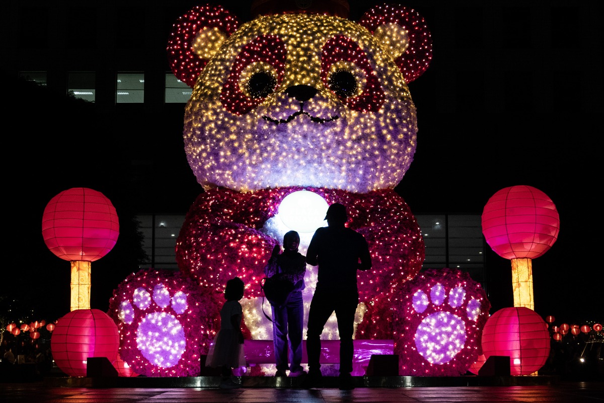 People stand in front of an illuminated giant panda decoration in celebration of the upcoming Lunar New Year in Jakarta, Indonesia, on Jan. 24, 2025. (Xinhua/Veri Sanovri)
