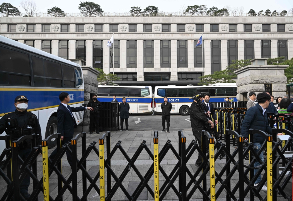 Security officials stand guard in front of the Constitutional Court in Seoul on March 24, 2025, ahead of the impeachment verdict for South Korean Prime Minister Han Duck-soo. (Photo by Jung Yeon-je / AFP)