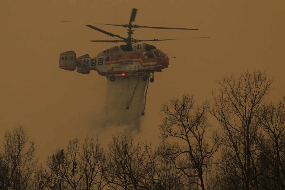 A helicopter takes part in an operation to extinguish a wildfire in Uiseong on March 24, 2025. Photo by YASUYOSHI CHIBA / AFP