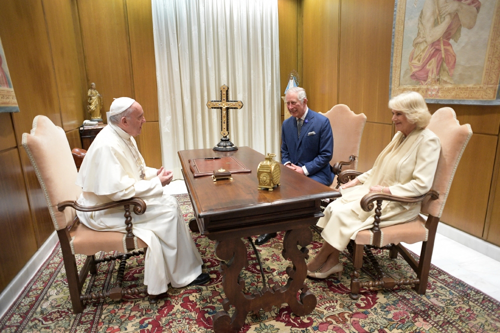 File: A handout photograph released by the Vatican press office shows Pope Francis speaking with then Britain's Prince Charles and his wife Camilla, Duchess of Cornwall, during a private audience on April 4, 2017 at the Vatican. (Photo by Osservatore Romano / AFP) 
