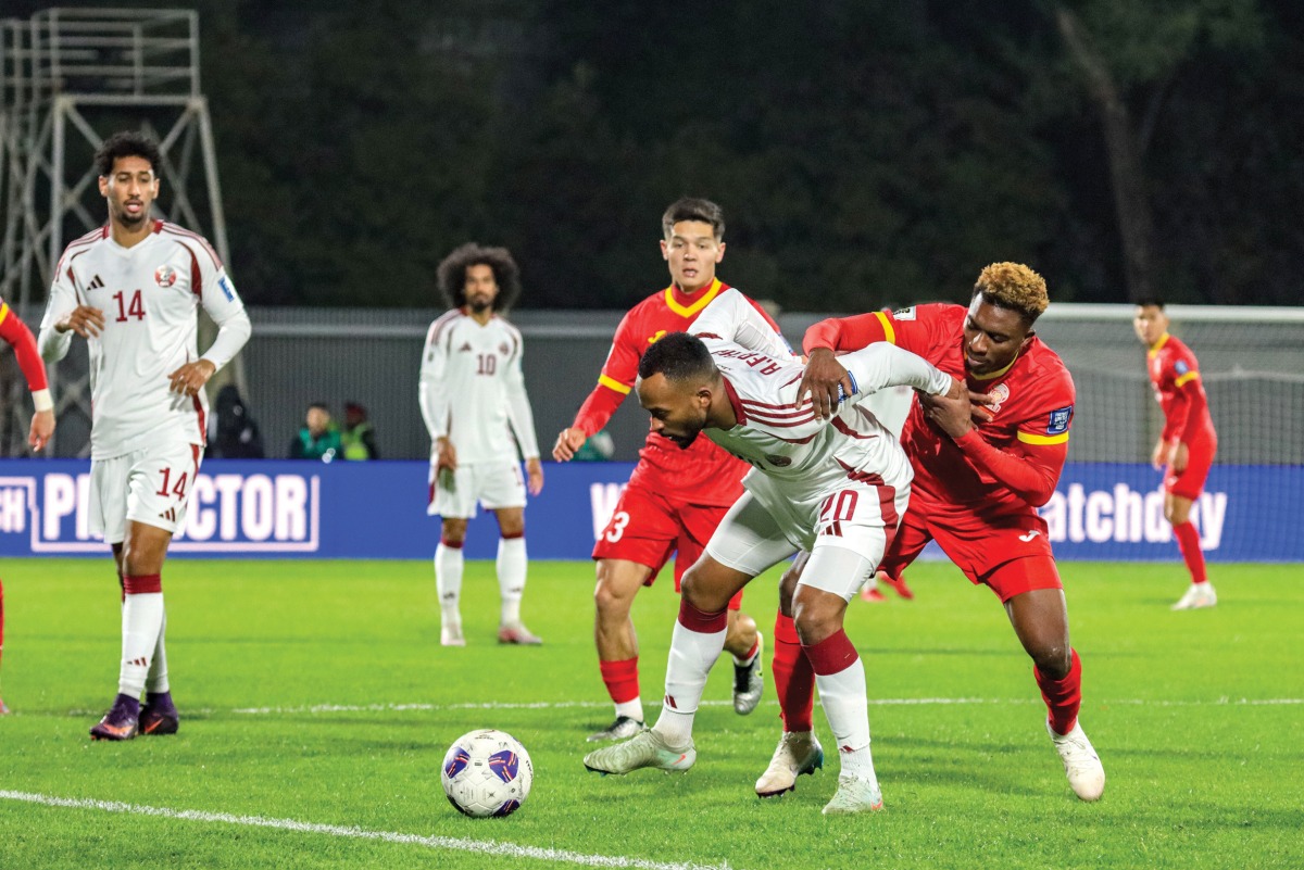 Qatar's Ahmed Fathy is challenged by Kyrgyzstan players during the match.