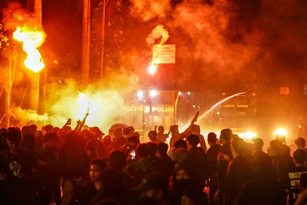 Anti-riot police disperse protesters during a demonstration against a revision to the armed forces law in front of the House of Representatives building in Jakarta on March 27, 2025. (Photo by Azwar Ipank / AFP)
