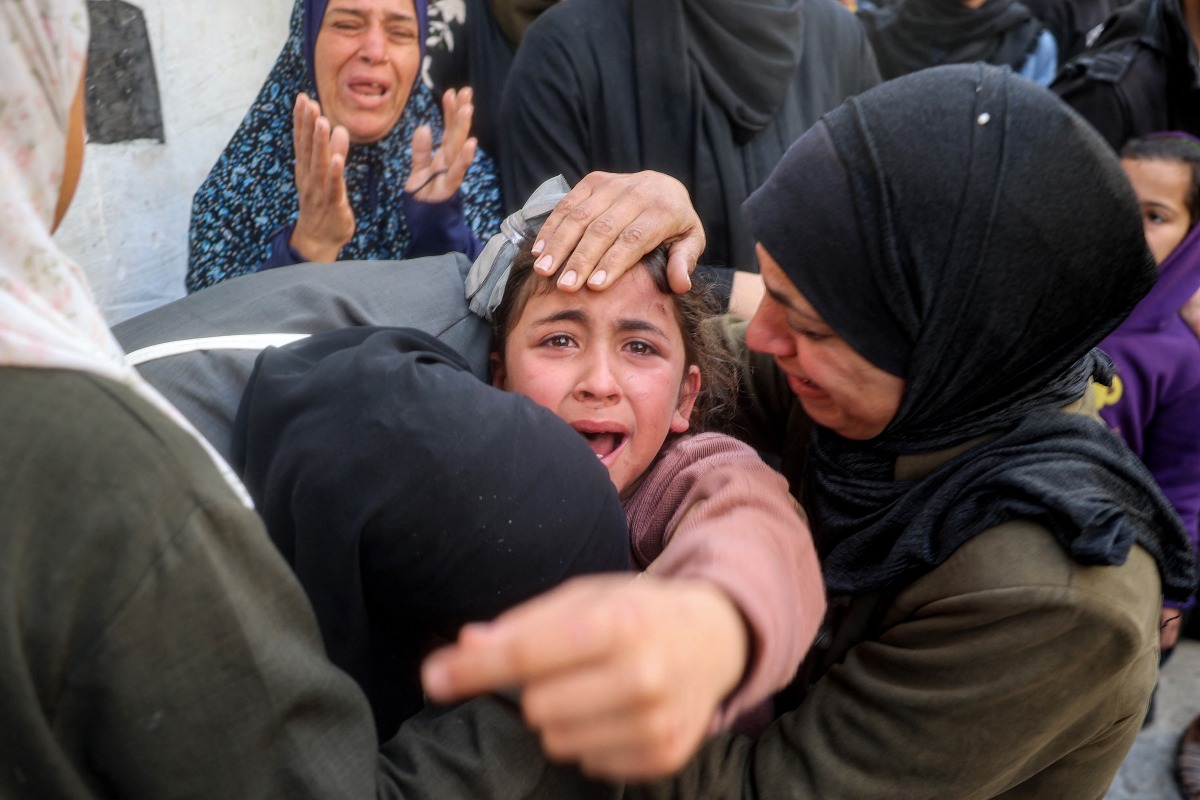 The young sister (C) mourns for her siblings and other members from the Abu al-Rous family who were killed when their house was hit by Israeli bombardment, during the funeral at the Bureij camp for Palestinian refugees in the central Gaza Strip on March 25, 2025. Photo by Eyad BABA / AFP