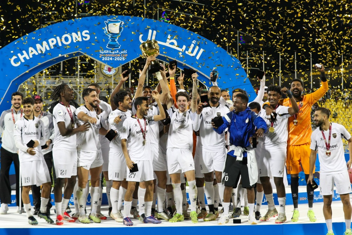 Al Bidda SC players and officials celebrate after winning the Second Division Cup trophy.