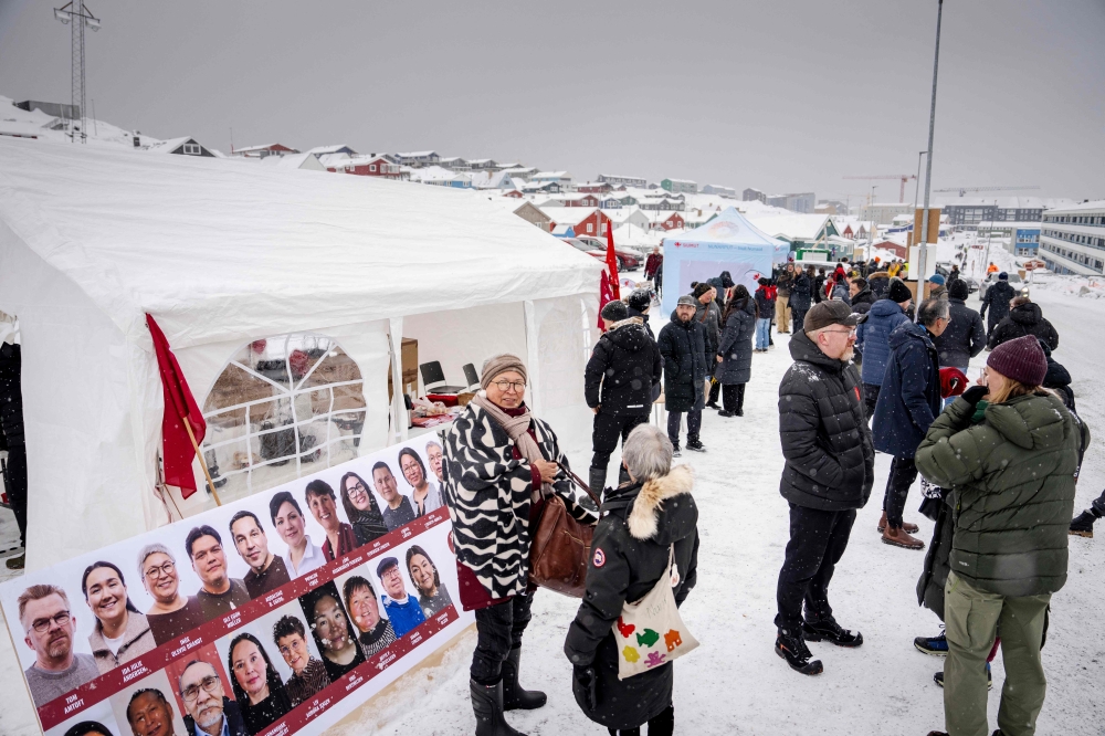 People stand in front of Godthaabshallen, where voting takes place in connection with the elections for the Greenlandic municipal councils, village councils, and parish representations in Nuuk, Greenland, on April 1, 2025. (Photo by Mads Claus Rasmussen / Ritzau Scanpix / AFP) 
