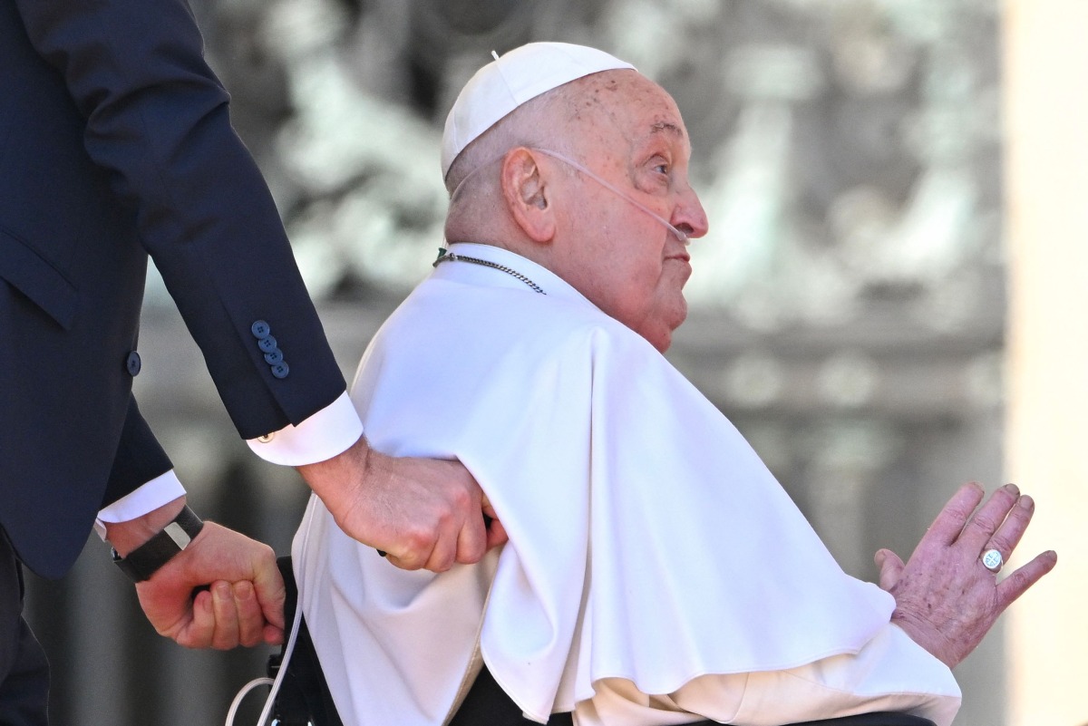 Pope Francis is pushed in his wheelchair after leading the Angelus prayer on St. Peter's square in The Vatican, on April 6, 2025. (Photo by Alberto PIZZOLI / AFP)