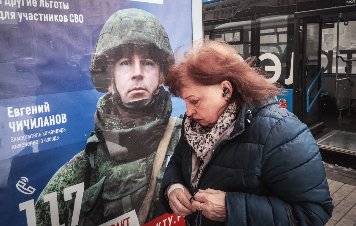 A woman walks past a poster promoting contract army service in western Moscow on April 9, 2025. Photo by Alexander NEMENOV / AFP.