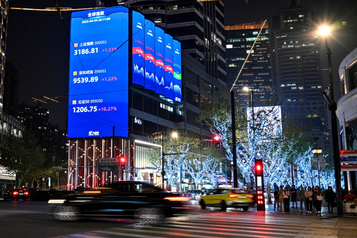 A screen showing the Shanghai composite index (top), Shenzhen component index (C) and Beijing stock exchange 50 index (bottom) is seen in Jing'an district in Shanghai on April 9, 2025. Photo by Hector RETAMAL / AFP