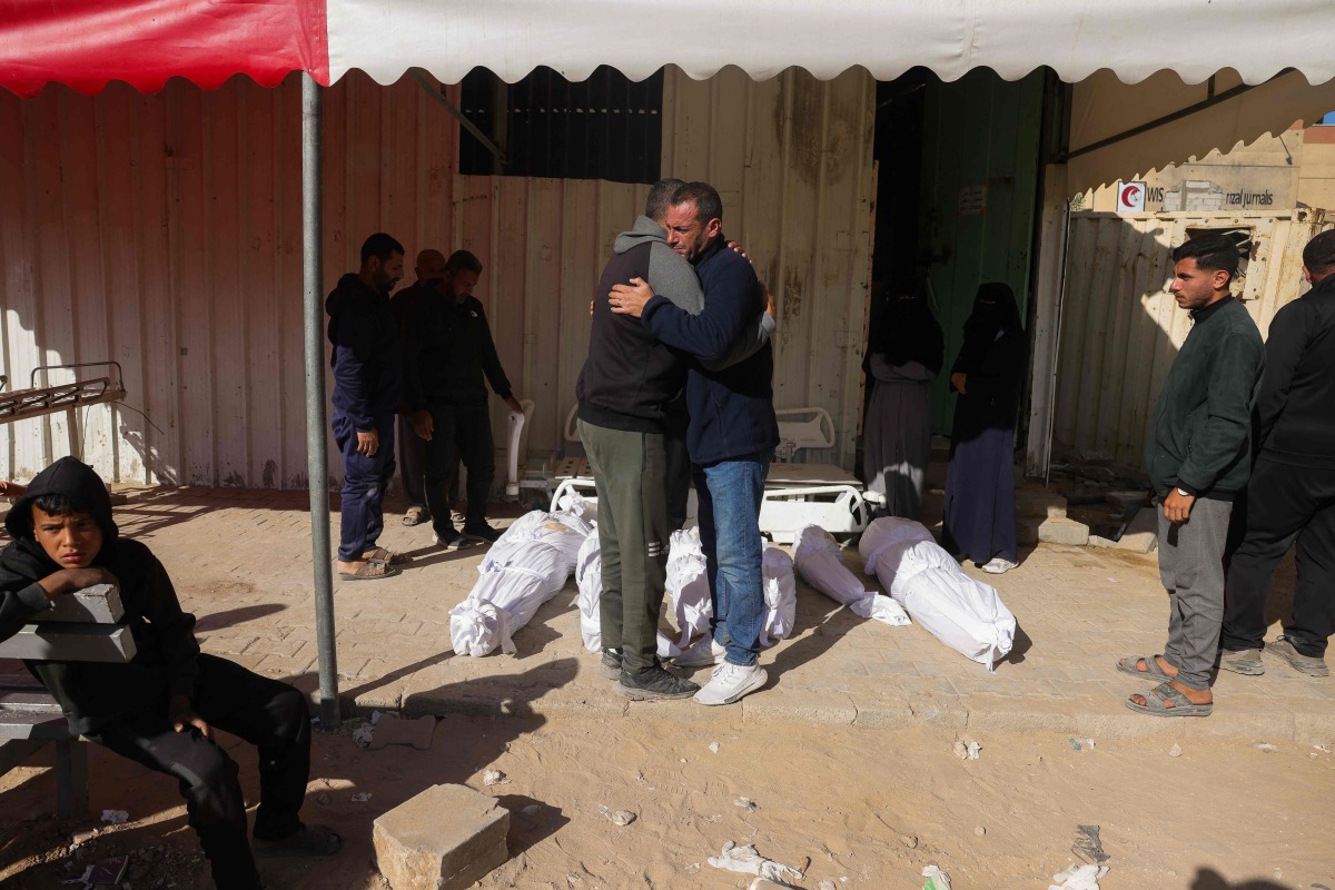 Palestinians mourn near the bodies of their relatives, killed in an Israeli strike, at the Indonesian Hospital in Beit Lahia on April 17, 2025. (Photo by BASHAR TALEB / AFP)
