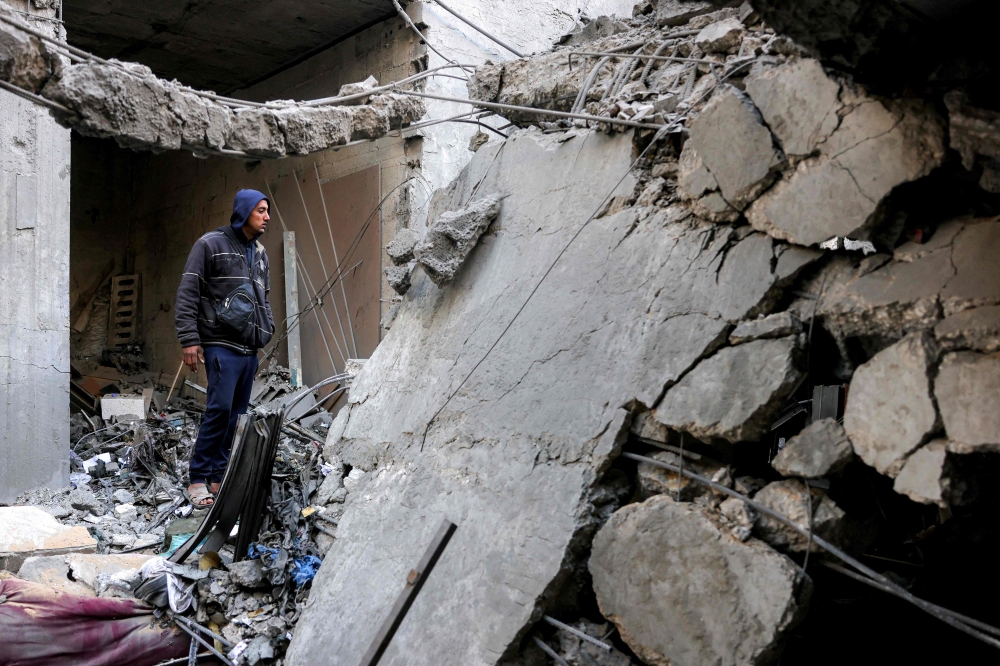 A man looks through the rubble to inspect a destroyed building that was hit by Israeli bombardment in Jabalia in the northern Gaza Strip on April 18, 2025.  (Photo by Bashar Taleb / AFP)
